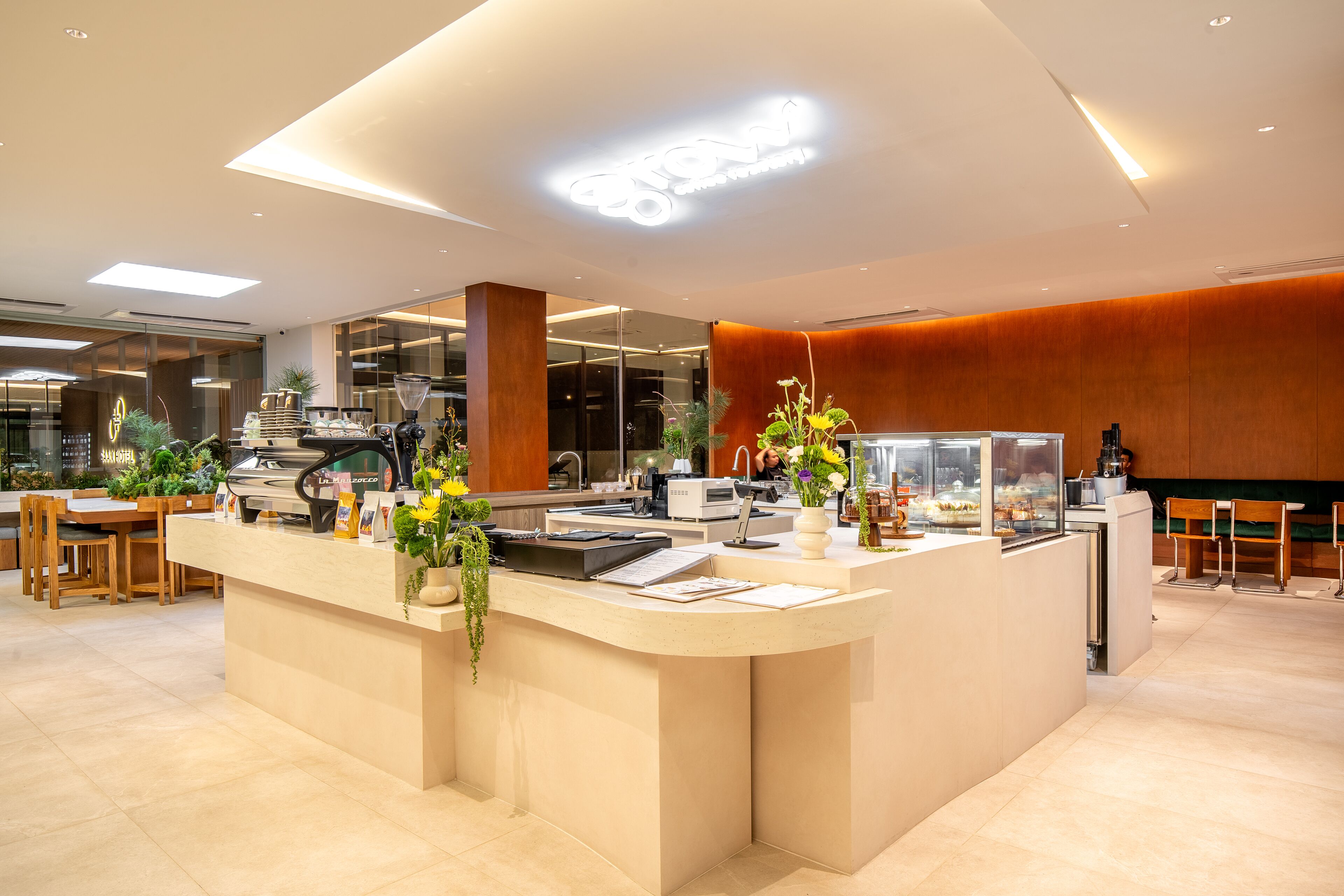 Un espace d’accueil moderne comprenant un comptoir, des sièges et une machine à café.