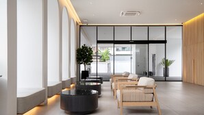 Een moderne lobby met zithoeken, een receptiebalie en grote ramen.
