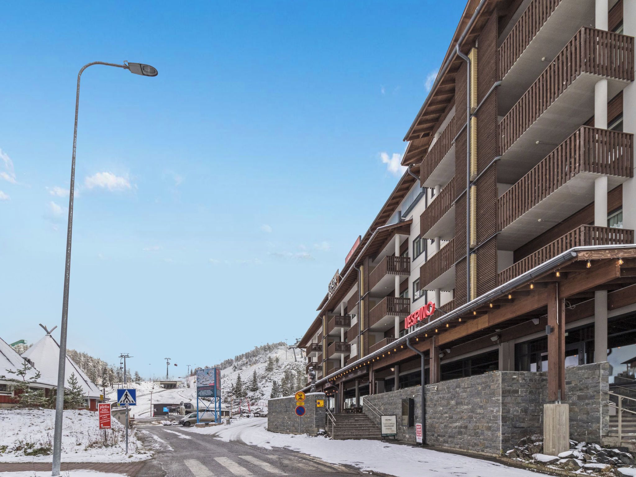 A multi-story hotel with a ski lift in the background.