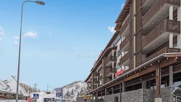 A multi-story hotel with a ski lift in the background.