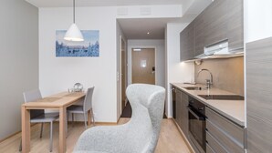 A modern kitchen with a built-in stove, a sink, and a dining area with a table and chairs.