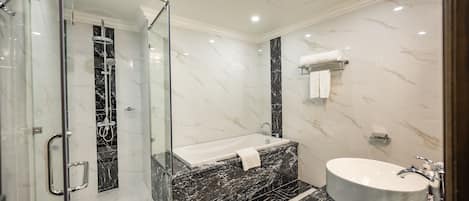 A modern bathroom with a glass-enclosed shower, a freestanding bathtub, and a round sink.