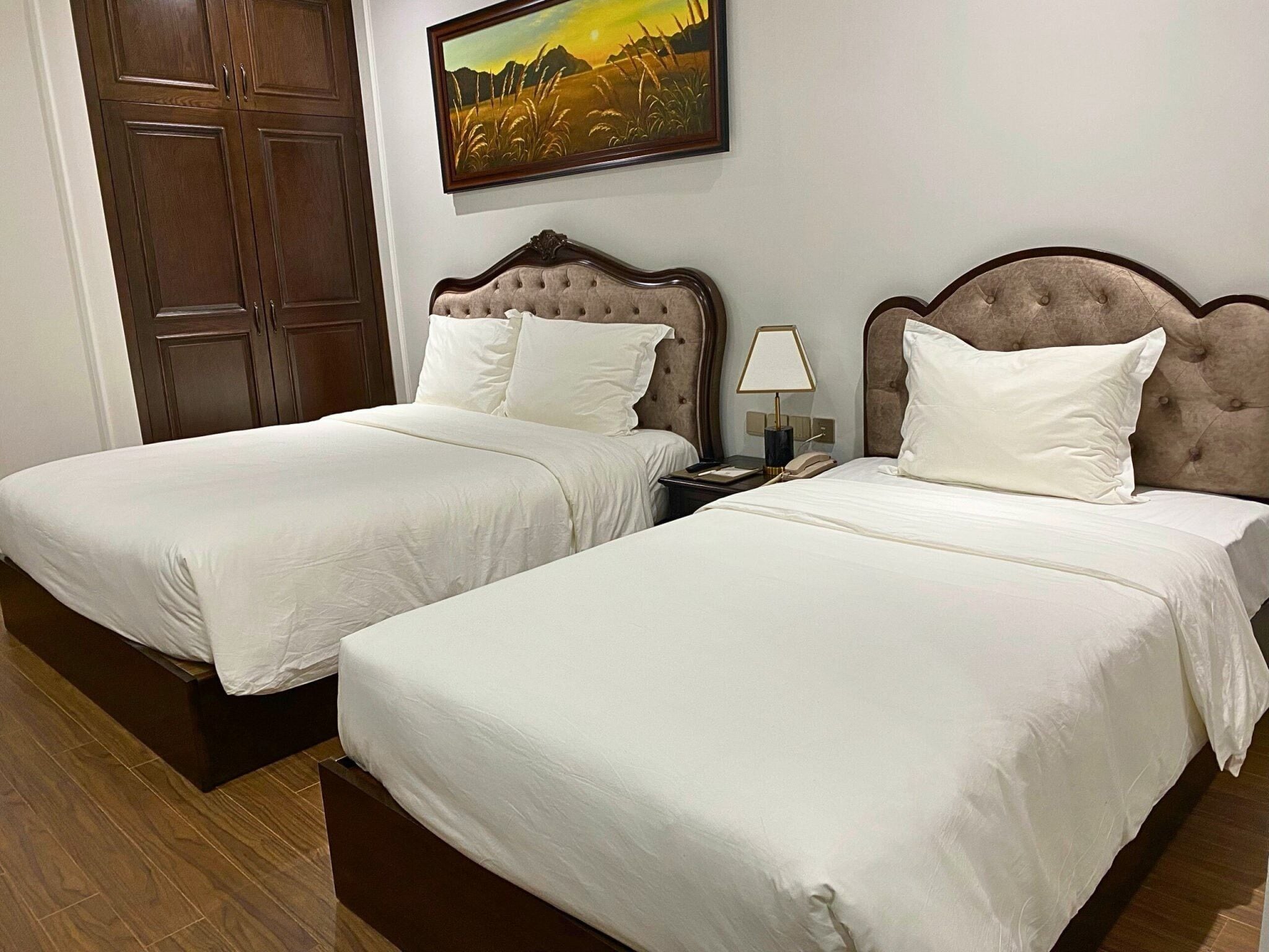 Two twin beds with white linens in a hotel room.