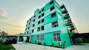 Um edifício de vários andares com telhado plano e varanda no lado direito.