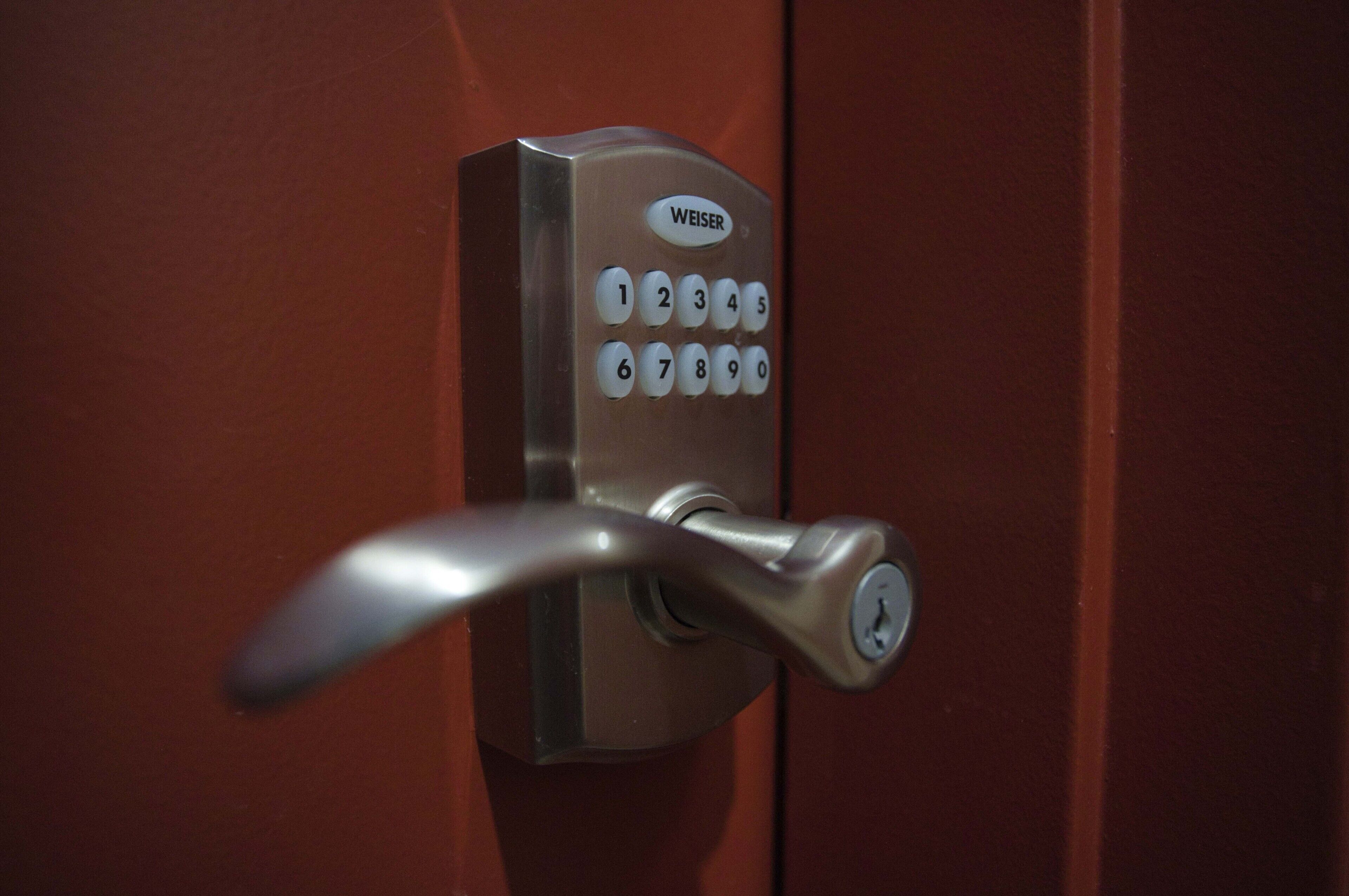A door with a numeric keypad lock labeled "WEISER".