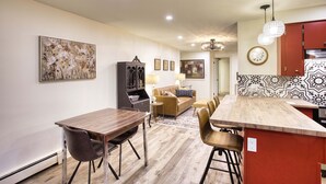 A modern kitchen with a wooden island, a dining area with a table and chairs, and a living room with a sofa and a coffee table. - Great for Couples or Family in Niagara Wine Country (Lincoln)