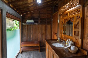 A wooden bathroom with a sink, mirror, and bench. - Bali Desa Asri (Keroboken Kelod)