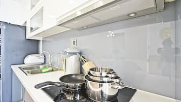 Appartement familial, 4 chambres, vue sur la ville | Cuisine privée | Vaisselle et ustensiles, table de salle à manger