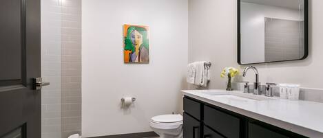 Ein modernes Badezimmer mit Toilette, Waschbecken und Spiegel.