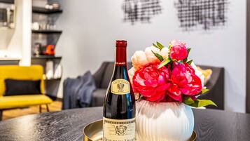 Une bouteille de vin sur un plateau, accompagnée d’un vase de fleurs.