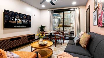 A modern living room with a sofa, coffee table, and TV mounted on the wall.