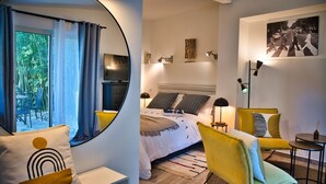 Een moderne slaapkamer met een bed, nachtkastjes, een stoel, een lamp en een schilderij aan de muur.
