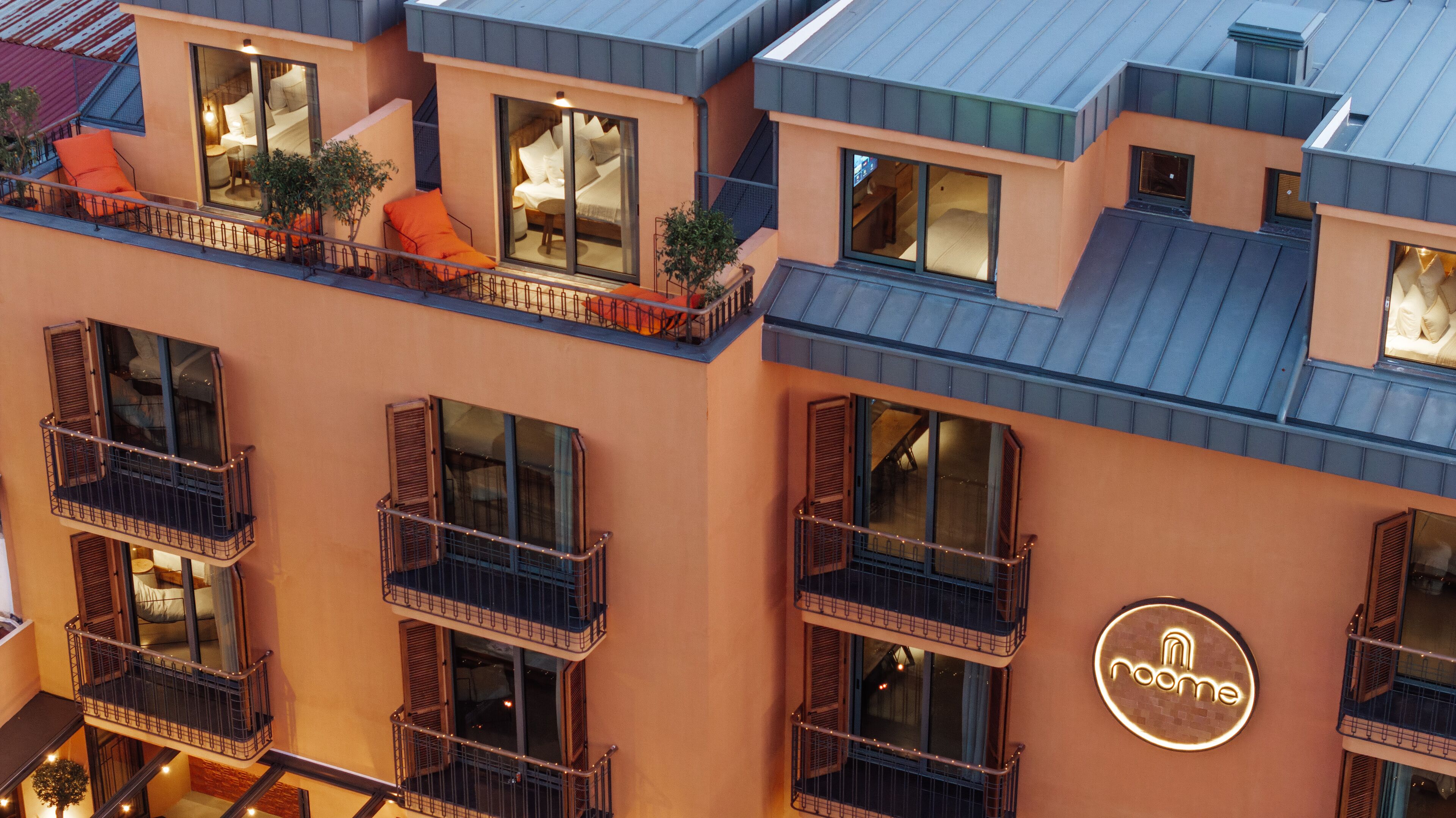 Un hôtel à plusieurs étages doté de balcons, de grandes fenêtres et d'une enseigne lumineuse au néon.