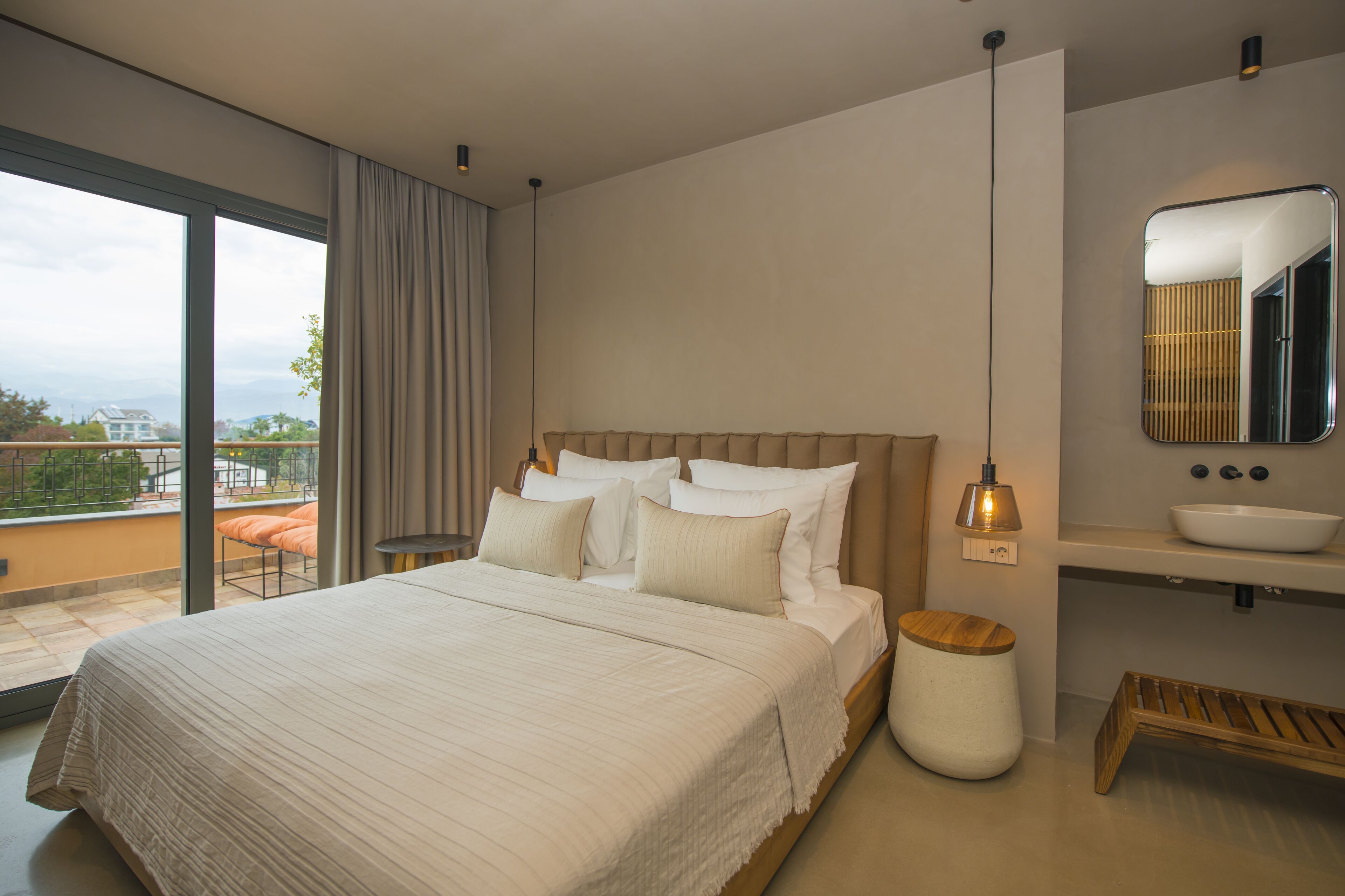 Een moderne slaapkamer met een groot bed, een nachtkastje, een spiegel en uitzicht op de omgeving.