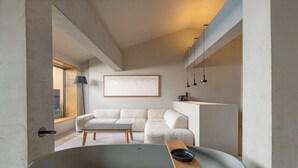 A modern living room with a large bathtub, a sofa, and a minimalist design. - Roome (Fethiye)