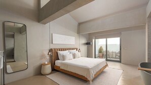 A modern bedroom with a large bed, a mirror, a bedside table, and a view of the outside balcony. - Roome (Fethiye)