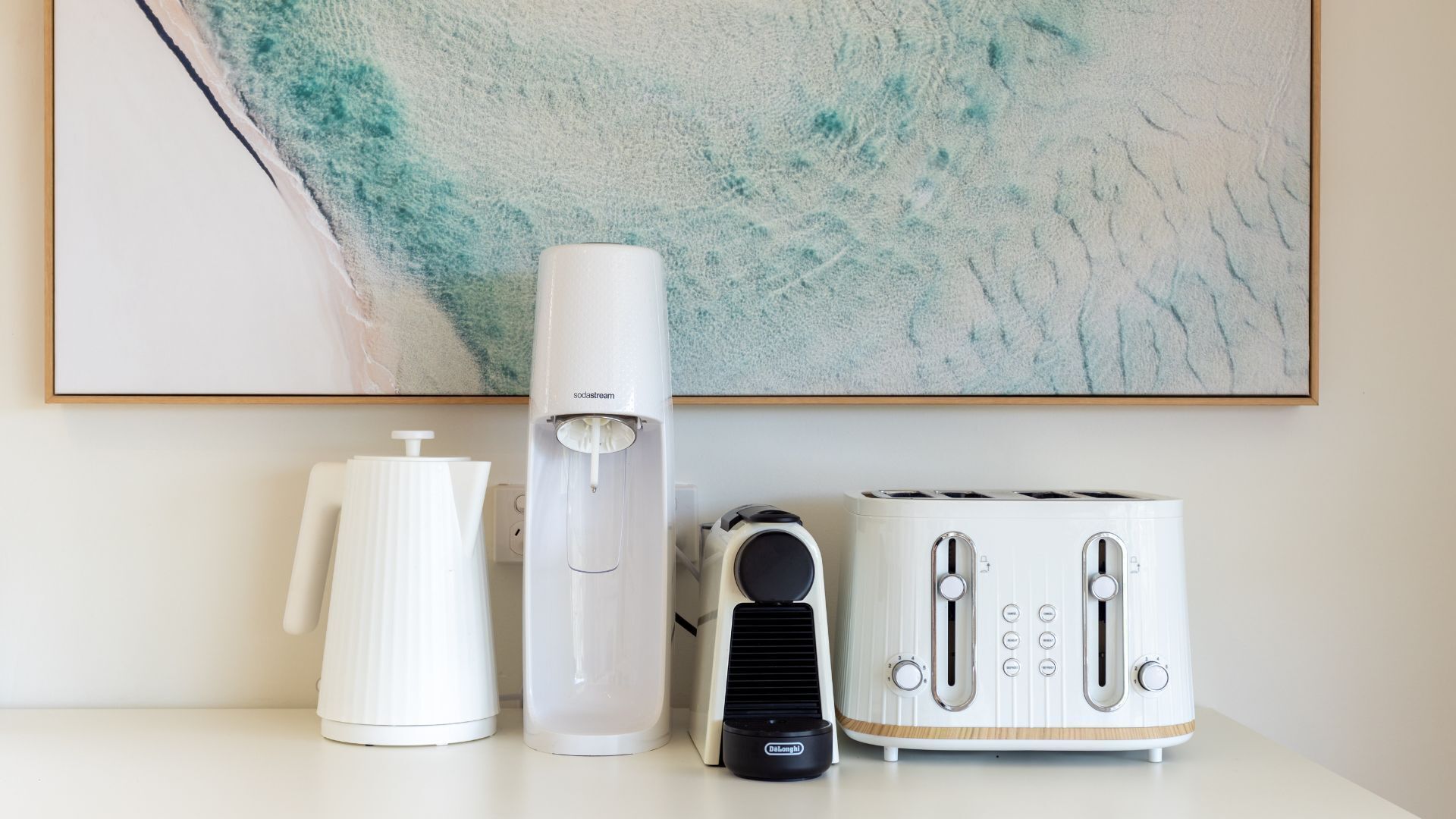 A kitchen counter with a coffee maker, a toaster, and a kettle.