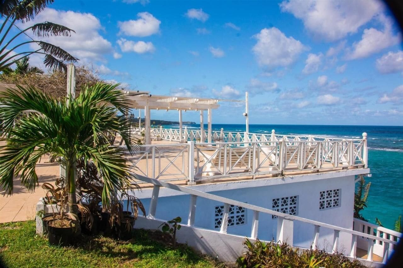 Un bâtiment blanc doté d’un balcon donnant sur l’océan.