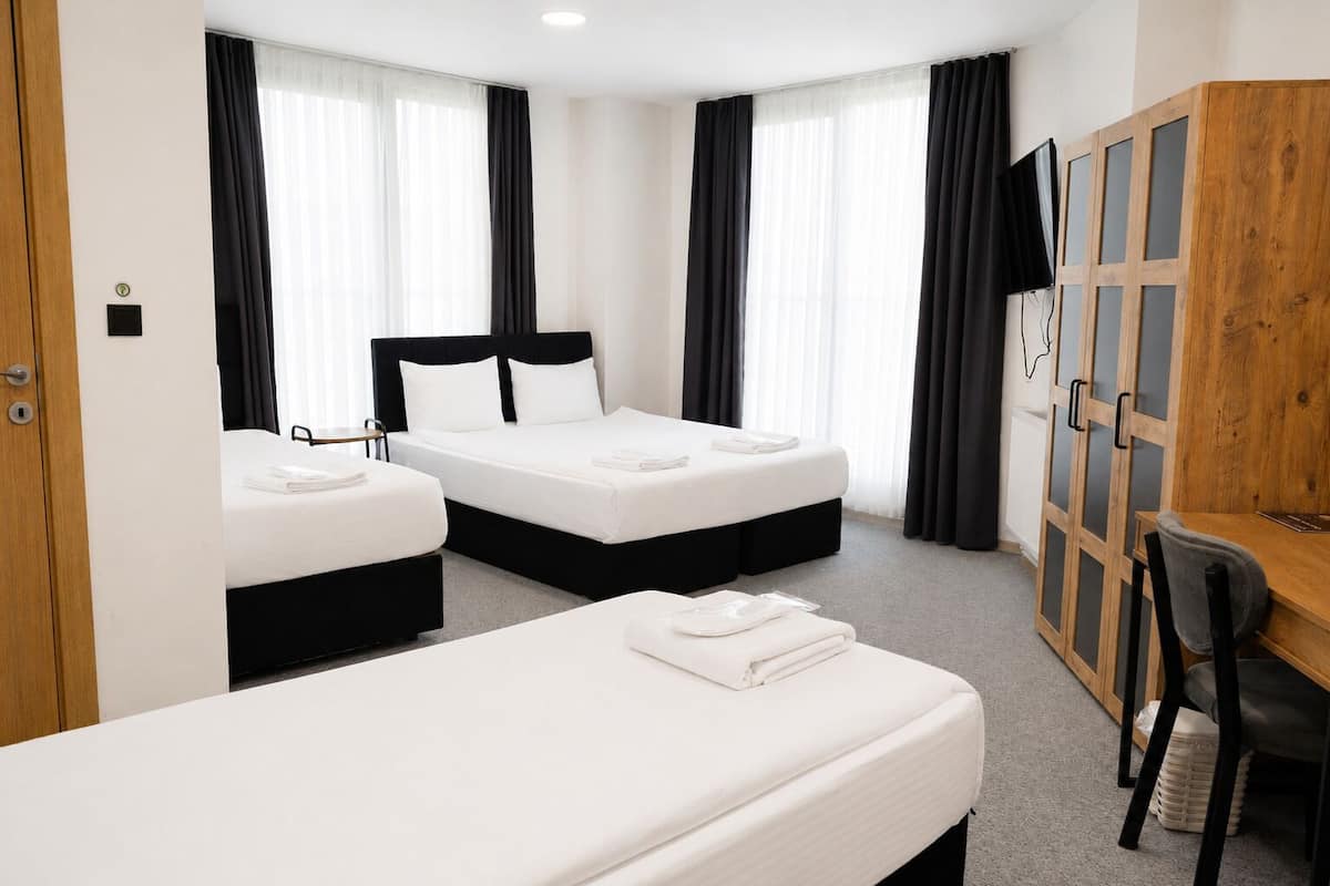 Habitación cuádruple Deluxe | Sábanas de algodón egipcio, ropa de cama de alta calidad, minibar