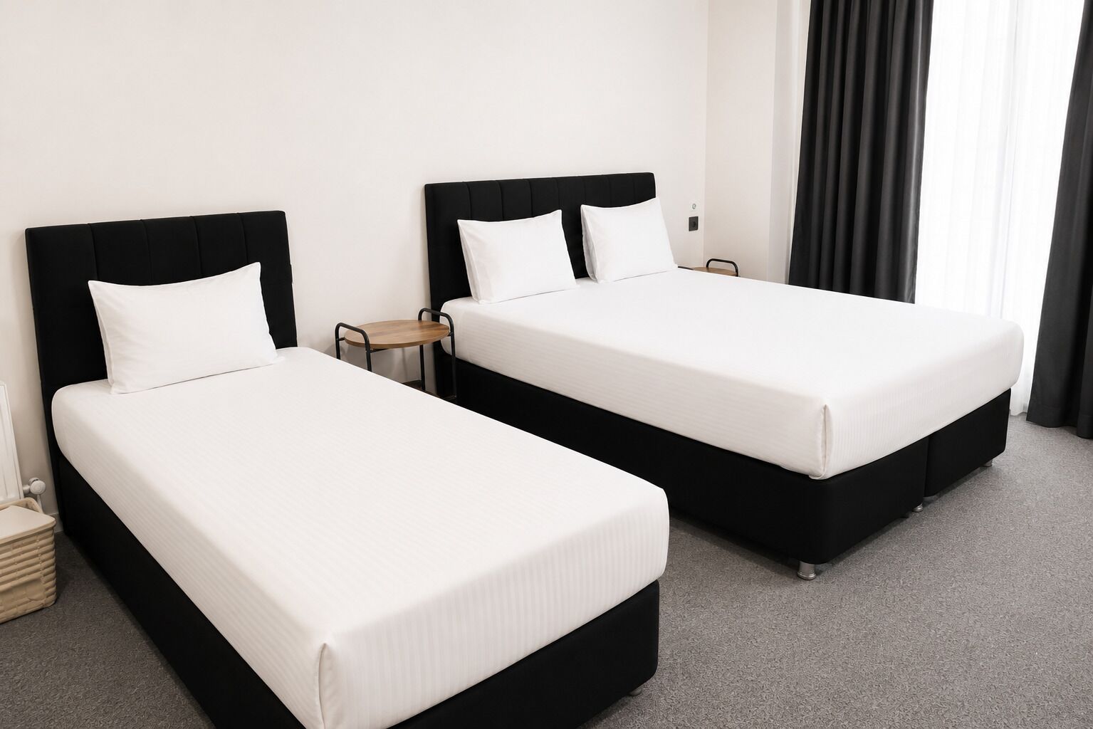 Una habitación de hotel con dos camas, una mesita y una mesilla de noche.