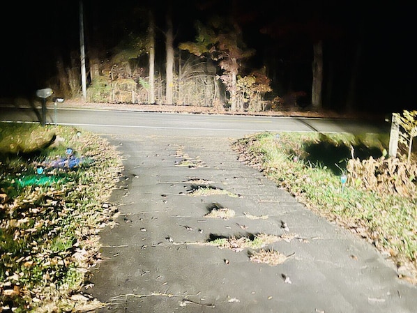 A damaged pathway with potholes and debris.