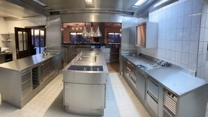 Una cocina moderna con electrodomésticos de acero inoxidable, una isla central y vistas a la ciudad a través de amplios ventanales.