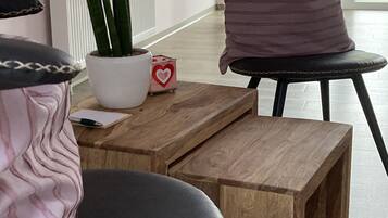 A modern room with a wooden table, a potted plant, and a chair with a cushion.