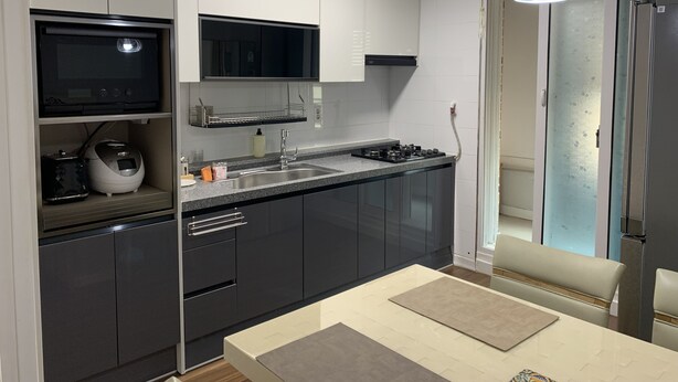 Una cocina moderna con microondas, estufa y pileta.