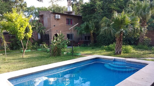 Una piscina rectangular con azulejos azules y un borde alicatado.