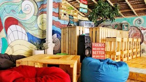 Ein gemütlicher Sitzbereich mit Holztisch, blauem Sitzsack und farbenfroher Wandmalerei.