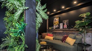 Una sala de estar moderna con un sofá verde, una mesa de centro y una pared de ladrillo.