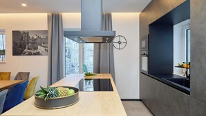 A modern kitchen with a central island, a built-in oven, and a large window providing a city view. - Hedera Estate, Villa Hedera XVII (Dubrovnik)
