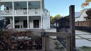 A two-story house with a porch and a fenced yard.