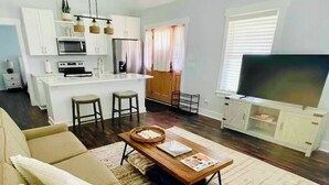 Una sala de estar moderna con un sofá, una mesa de centro y un televisor.