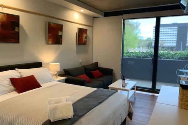 Homey and tidy bedroom built with sliding door mirrored cabinets where you can place your clothes and other belongings orderly. There is also a transparent glass wall to see the amazing view outside.