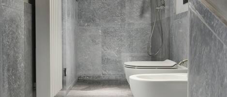 Un baño moderno con una bañera independiente, cabina de ducha y retrete.