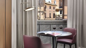 A table with two chairs, a book, and two wine glasses. - The Bank Hotel - Etruria Collection (Perugia)