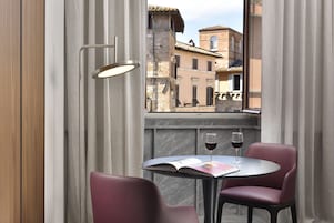 Una mesa con dos sillas, un libro y dos copas de vino.