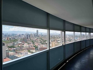 A long corridor with large windows offering a cityscape view.