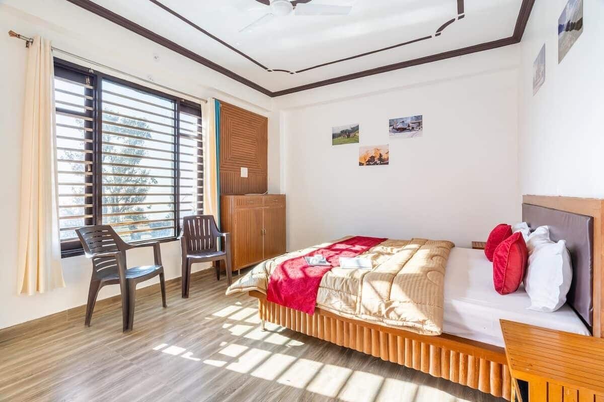 A bedroom with a bed, a desk, and a chair. There are pictures on the wall.