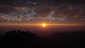 Un atardecer sobre un paisaje montañoso con cielo despejado.