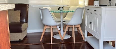 Un comedor con una mesa y sillas, un sofá, un armario y un cartel en la pared.