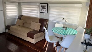 A compact living space with a sofa, two chairs, a small table, and a wall-mounted sign. - Cozy place in Calusa Key Largo (Key Largo)