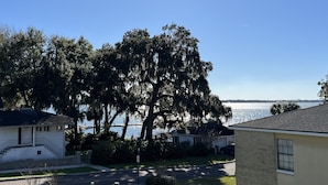 A residential area with houses, a lawn, and a body of water in the background.