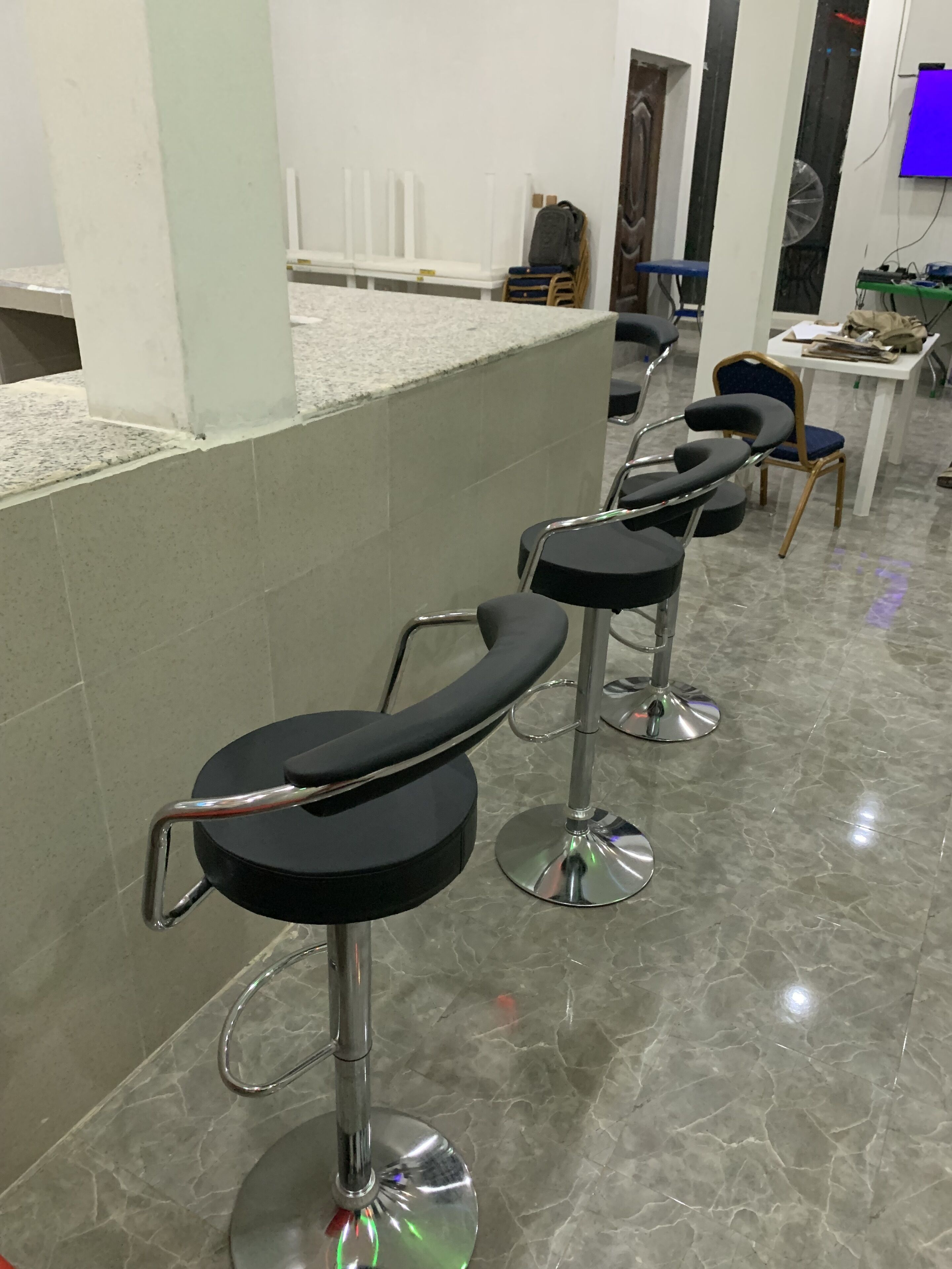 Un espace bar avec des tabourets hauts et un comptoir.