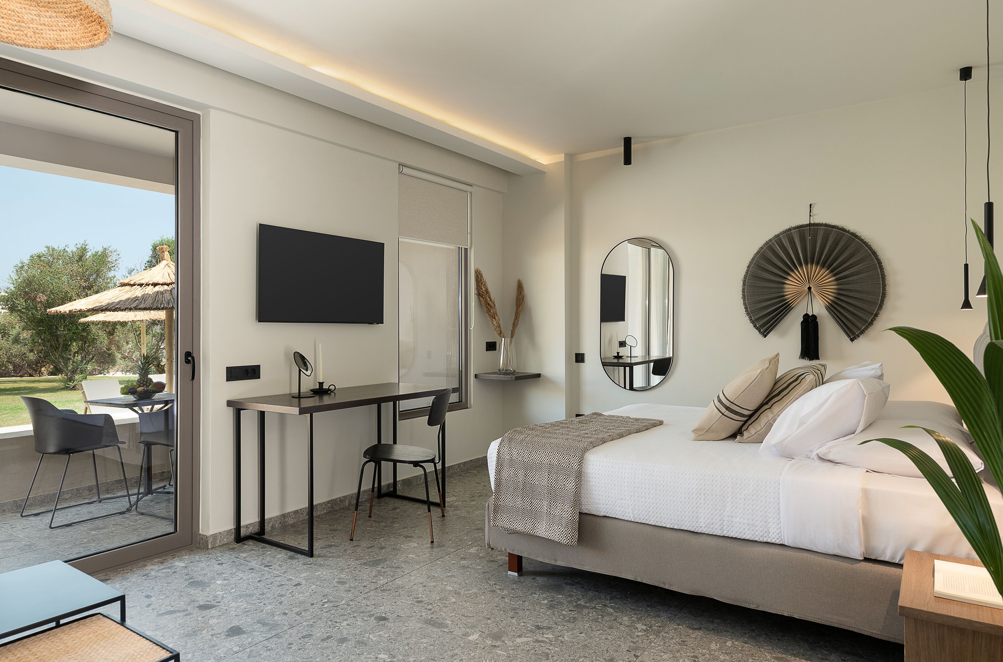 A modern bedroom with a bed, desk, and chairs.
