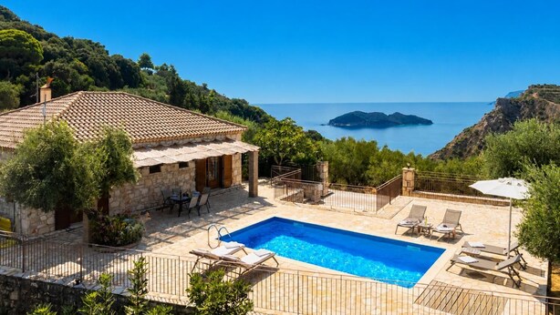 Une villa en pierre dotée d’une piscine, d’un espace extérieur aménagé et offrant une vue sur la mer.
