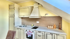 A compact kitchen with a built-in oven, a sink, and a window above the countertop.