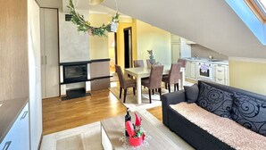 A modern apartment with a dining area, kitchen, and living room.