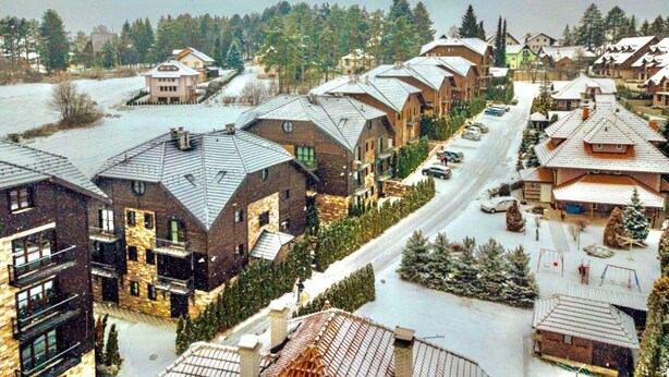 A residential area with houses featuring sloped roofs and a central road.